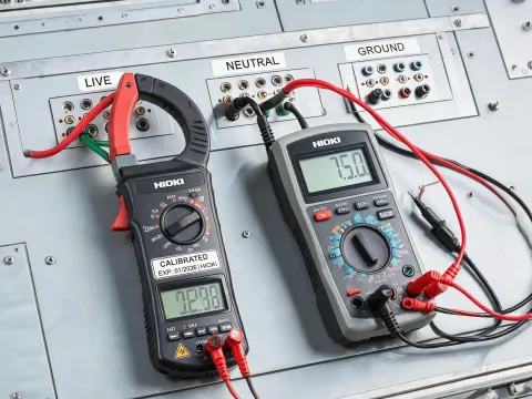 Clamp meter and multimeter on electrical panel